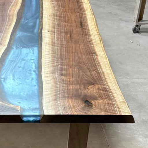 Modern dining table top blending turquoise epoxy and natural wood grain.