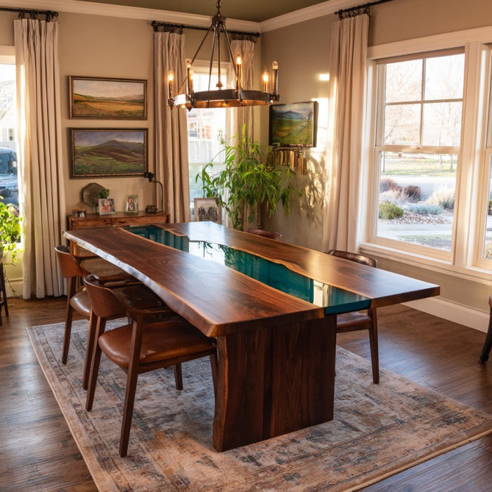 Dining room with a long wooden table and chairs, large windows, and decorative elements.