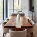 Modern dining area with a wooden table and chairs in a well-lit room.