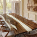 A black walnut and white resin epoxy dining table in a modern luxury home dining space with natural light.