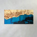 Modern resin dining table featuring deep blue and black resin inlay with warm poplar wood and a sleek straight edge design.