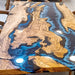 Blue resin river dining room table with unique live edge design