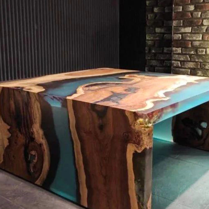 Wooden table with a unique design against a brick wall.