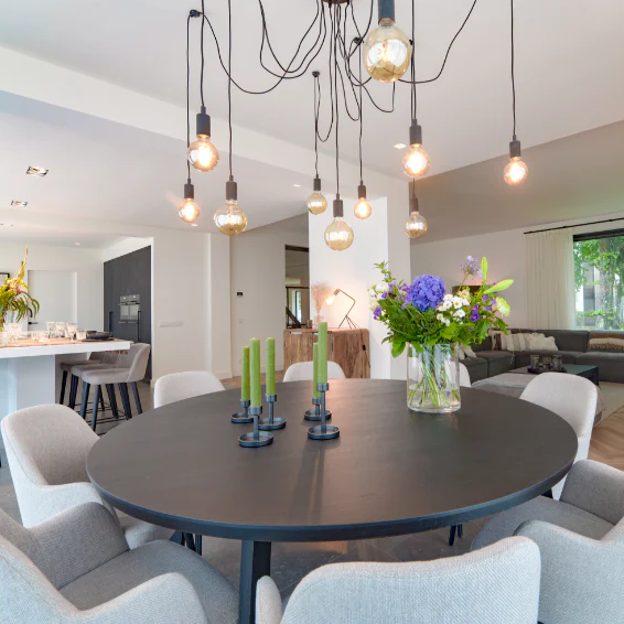 Modern dining room with a round table, chairs, and decorative elements.