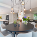 Modern dining room with a round table, chairs, and decorative elements.