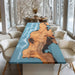 Dining room with a unique wooden table featuring a blue resin design.