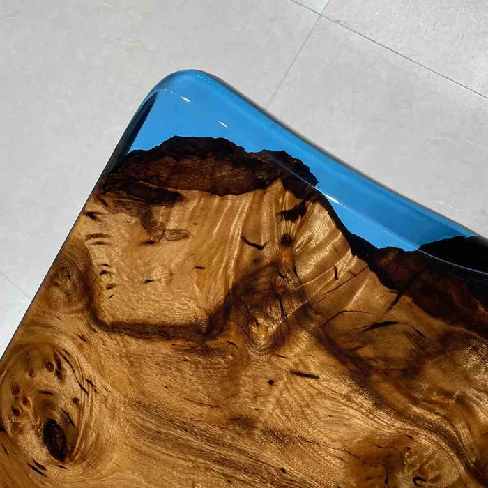 Wooden surface with blue resin finish on a light gray floor