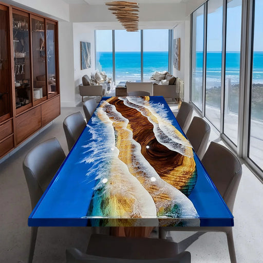 Dining room with a colorful resin table and large windows overlooking the ocean.