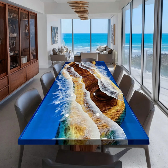 Dining room with a colorful resin table and large windows overlooking the ocean.