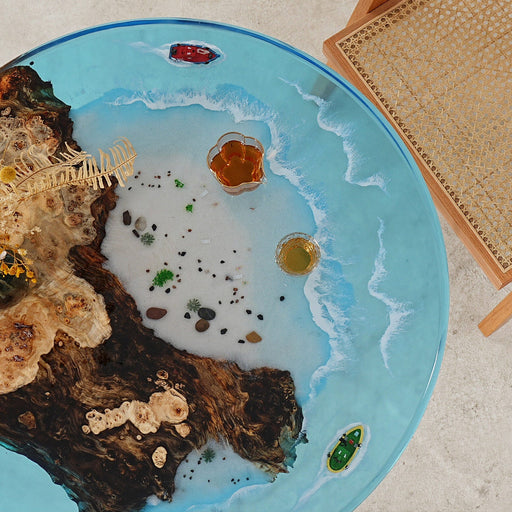 Luxury ocean-themed epoxy table with clear acrylic legs and detailed shoreline effects in blue resin.