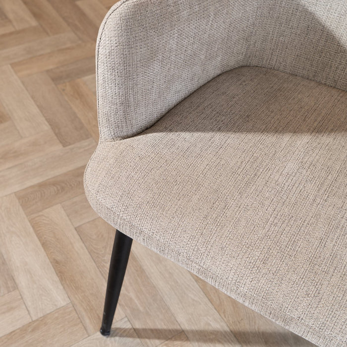 Beige armchair on a wooden floor with a herringbone pattern