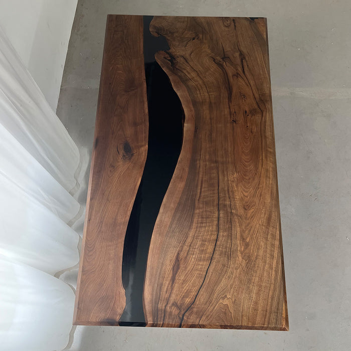 Black epoxy river dining table in a modern kitchen with mountain view.