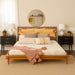 Wooden bed with floral headboard in a bedroom setting