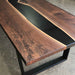 Wooden table with black resin finish on a concrete floor
