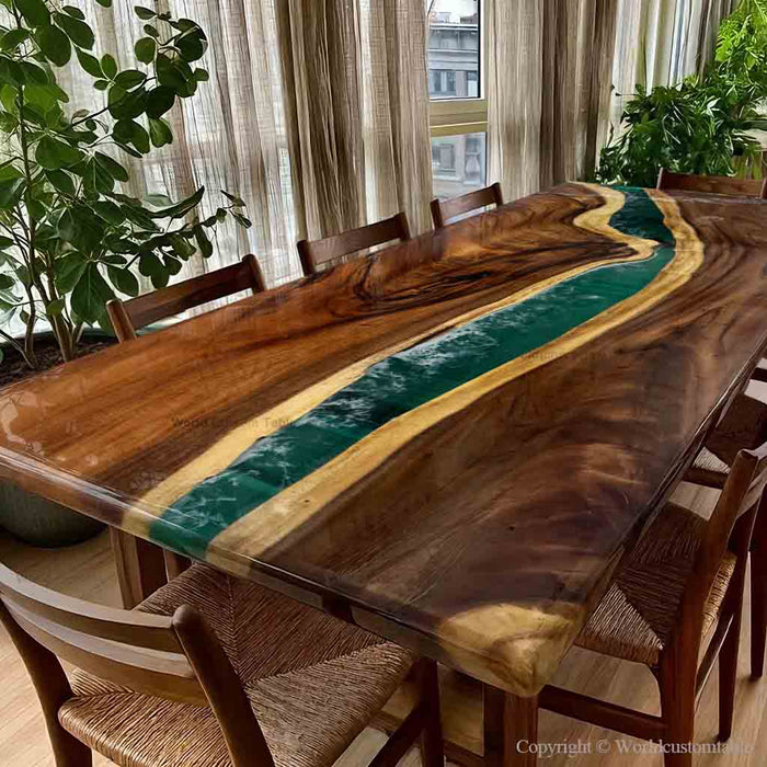 Wooden dining table with green epoxy resin inlay in a room with plants and curtains.