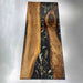 Custom black walnut epoxy river table featuring black resin with preserved flower details and natural wood grain