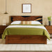 Wooden bed with green bedding in a bedroom setting