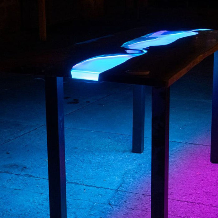 Custom black walnut coffee table with glowing blue epoxy