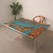 Table with a unique design featuring blue resin and brown wood patterns, placed against a plain wall.