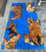 Custom handcrafted dining table combining natural wood slabs with vivid blue epoxy resin, set in a contemporary interior