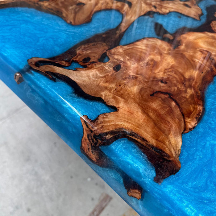 Wooden coaster with blue resin on a white surface