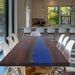 Handmade epoxy river table with live edge wood and blue resin.