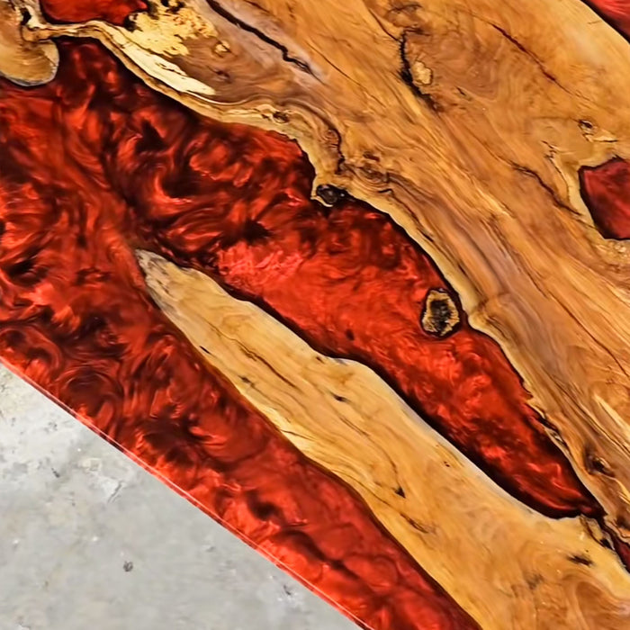 Custom handcrafted epoxy and wood table with unique red resin swirls