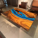 A custom handcrafted epoxy coffee table with rich walnut grain and a blue river design.