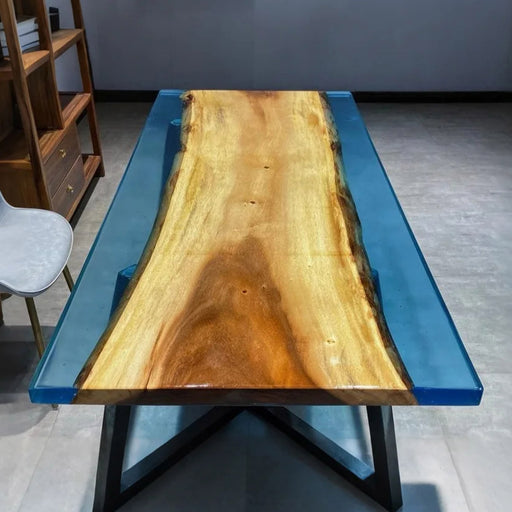 Ocean-inspired epoxy river table with natural wood slabs, featuring vivid blue resin that mimics the look of flowing water for a stunning furniture statement piece.