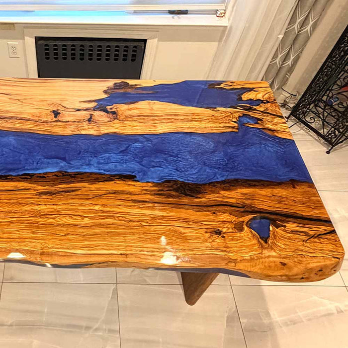 Custom handmade olive wood blue epoxy river table crafted by skilled artisans in California.