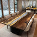 Dining room with a large wooden table and chairs, featuring a snowy outdoor view.