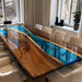 Dining table with wooden surface and blue resin inlay in a modern interior setting.