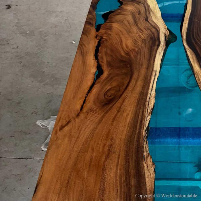 Wooden table with blue resin finish on a concrete floor