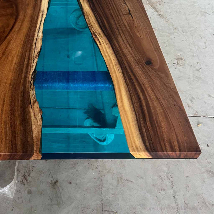 Wooden table with a blue resin inlay on a concrete floor