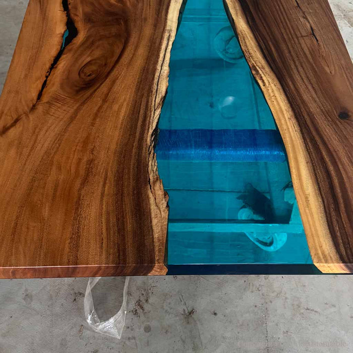Wooden table with a blue resin inlay on a concrete floor