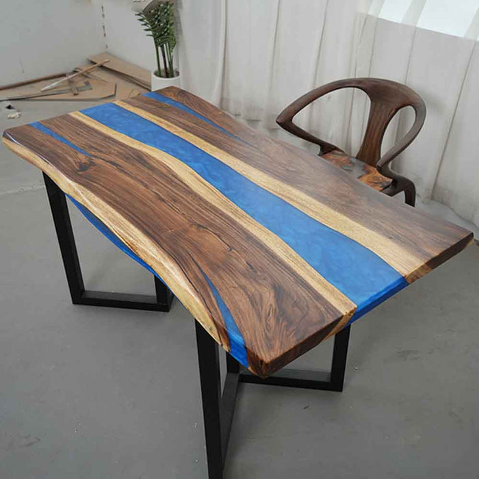 Wooden desk with blue resin inlay and chair in a room setting