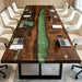 Close-up of the swirling green epoxy river pattern on a black walnut conference table