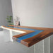 Custom L-shaped epoxy resin kitchen countertop featuring walnut wood and mysterious blue resin