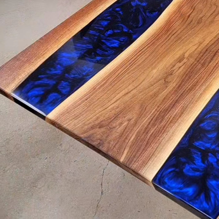 Live edge walnut river table featuring deep blue swirling resin center