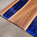 Live edge walnut river table featuring deep blue swirling resin center