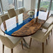 Detailed view of a swirling blue metallic epoxy resin river flowing between live edge walnut wood slabs.