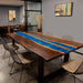 Dining room with a wooden table featuring a blue resin inlay and chairs.