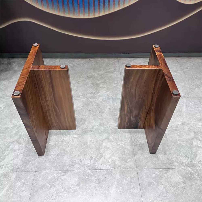 Two wooden stools on a tiled floor with a dark wall in the background