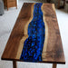 Custom black walnut and resin dining table with rich blue
