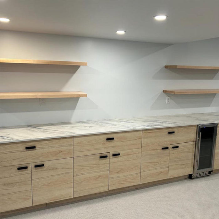 Modern kitchen with wooden cabinets, marble countertops, and open shelves.