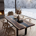 Dining table with chairs in a room with a large window view of a snowy landscape.