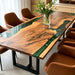 Top-down view of a walnut wood epoxy river table with deep emerald green resin and live-edge grain.