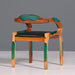Wooden chair with green accents and black seat on a gray background