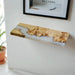 Wooden shelf with resin finish on a white wall, framed picture above