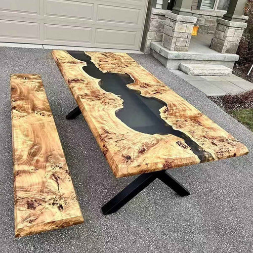 Handcrafted epoxy resin river table with intricate natural burl wood top, combined with sleek black metal legs, blending rustic textures with industrial style for unique dining experiences.